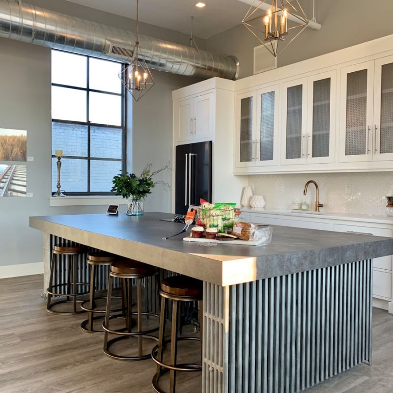 gray metal island table near white wooden kitchen cabinet